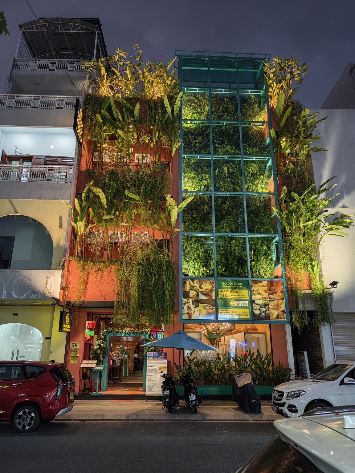 76 Hùng Vương 分店夜間外觀，綠色玻璃框與垂掛植栽