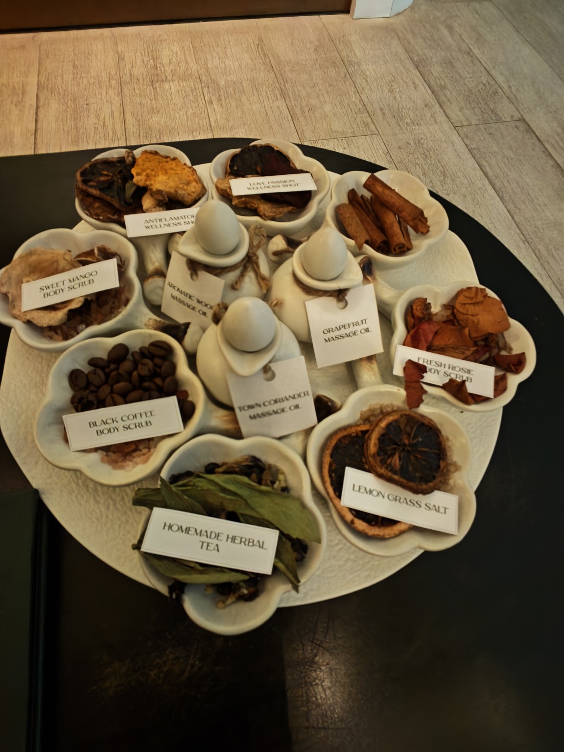 展示桌上有咖啡、芒果、玫瑰磨砂材料,以及按摩油與草本茶。
